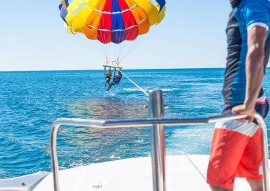 Mutlu çift Parasailing Dominicana içinde plaj yaz aylarında. İki orta hava asılı paraşüt altında. Eğleniyor. Tropik cenneti. Olumlu insan duyguları, duygular, joy. Aile bahar tatil.