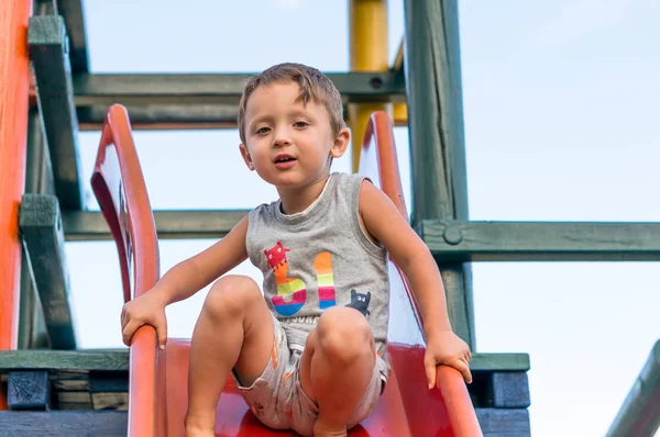 Усміхнений маленький хлопчик сидить і грає з піском — стокове фото