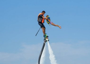 Baba ve kızı Karayip tropik sahilde yeni flyboard, poz. Olumlu insan duyguları, duygular, joy. Tatil yapma ve yaz zevk komik şirin çocuk.