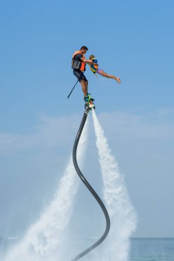 Baba ve kızı Karayip tropik sahilde yeni flyboard, poz. Olumlu insan duyguları, duygular, joy. Tatil yapma ve yaz zevk komik şirin çocuk.