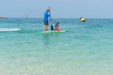 Yaz plaj tatil sırasında eğlenmek kurulu baba ve sevimli küçük kızı otururken ayağa