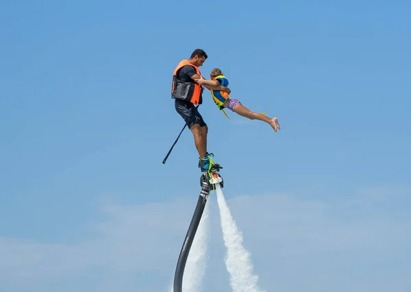Baba ve kızı Karayip tropik sahilde yeni flyboard, poz. Olumlu insan duyguları, duygular, joy. Tatil yapma ve yaz zevk komik şirin çocuk.