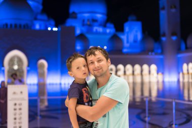 Sevimli oğlu Şeyh Zayed abaya, paranja gece zamanında giyen Camii Abu Dabi grand cami de rüya babası olan anne. Seyahat. Konsept reklam poster Dubai, Abu Dabi için.