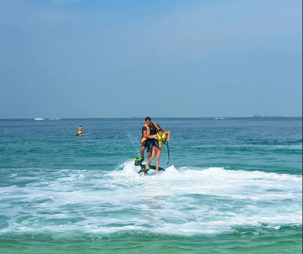 아버지와 카리브해 해변에서 새로운 Flyboard에서 긍정적인 인간의 여름을 즐기고 귀여운 — 스톡 사진