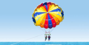 Happy couple Parasailing in Dominicana beach in summer. Couple u clipart