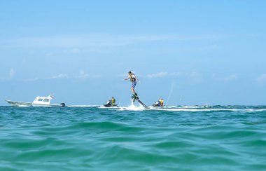 Adam Karayip tropik sahilde yeni flyboard, poz. Olumlu insan duyguları, duygular, joy. Tatil yapma ve yaz zevk komik, sevimli adamlar.