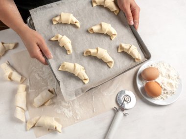 Kız kruvasan ile bir fırın tepsisi tutan