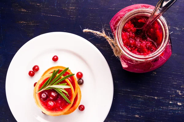 Winter one bite-sized snack or dessert: tartlets with sweet and sour cranberry sauce
