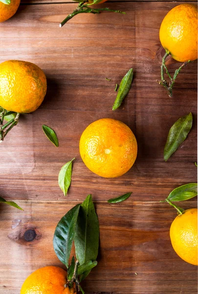 Tangerines with leaves on the wooden table — Stock Photo, Image