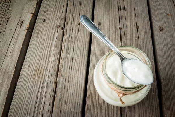 Yogur orgánico casero en un frasco con una cucharadaYogur orgánico casero — Foto de Stock