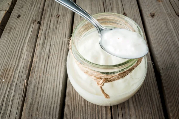 Yogur orgánico casero en un frasco con una cuchara — Foto de Stock