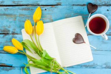 Çay, Lale ve mavi masa üstünde defter