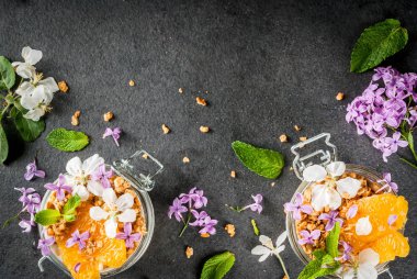 Granola, portakal, nane ve yenilebilir çiçekler ile yoğurt