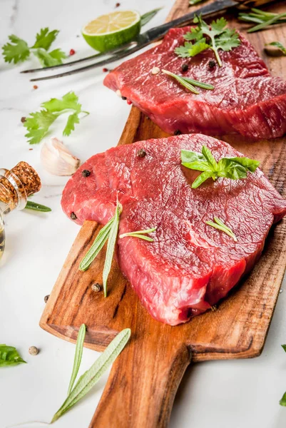 Carne crua fresca. Lombo de vaca, bifes, sobre uma mesa de mármore branco — Fotografia de Stock
