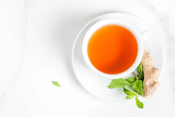 Tasse de thé au gingembre avec citron, menthe fraîche et miel, sur fond blanc — Photo