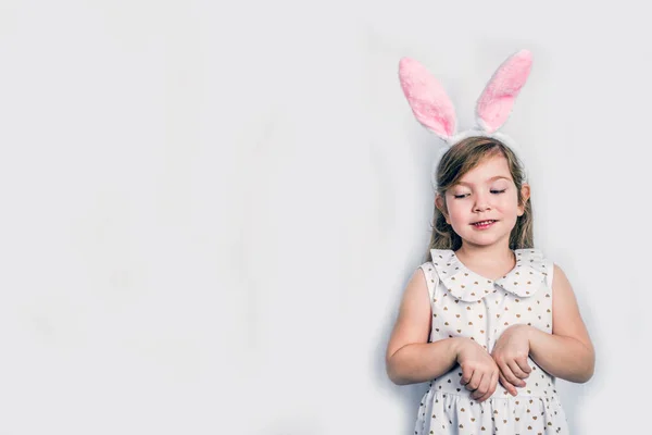 Glückliches nettes Mädchen mit Hasenohren. Ostergrußkarte Hintergrund — Stockfoto