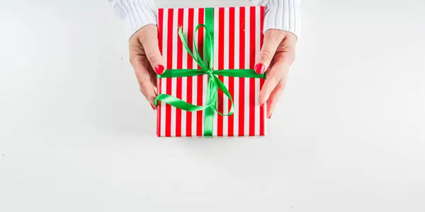 Dámské ruce drží vánoční dárkové krabice, šampaňské a sklenice — Stock fotografie