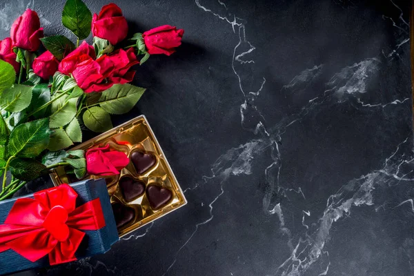 Valentijnsdag met rode rozen en chocolade hartjes — Stockfoto