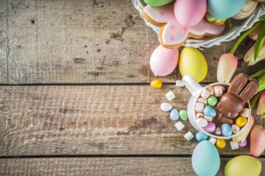 Çikolatalı tavşanlı sıcak Paskalya çikolatası. Paskalya yumurtaları ve marşmelov, bahar çiçekleriyle ahşap zemin kopyalama alanı