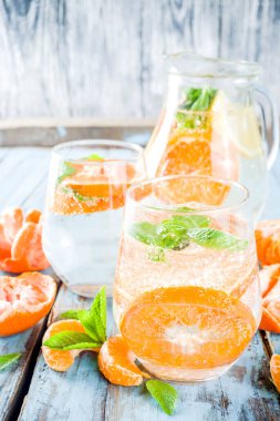 Yaz mandalina narenciye içecek, limonata veya mojito, taze mandalina, limon ve nane mavi ahşap masada,