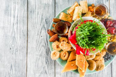 Mutlu Nevruz tatil arka plan. Kutluyor Nevruz tatlılar ve muamele etmek-baklava, çeşitli kurutulmuş meyveler, fındık, tohum, yeşil çim ile ahşap arka plan boşluk üst görünüm Kopyala