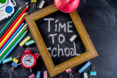 Siyah kara tahta arka planda okul eğitim malzemeleri. Okul konseptine geri dönelim. Üst görünüm düz metin için kopya alanı ile yatıyordu