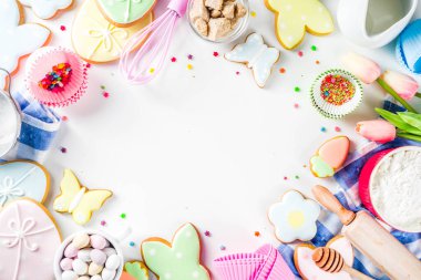Geleneksel Paskalya tavşanı ve yumurta kurabiyeleri, şeker parçacıkları, malzemeler, çatal bıçaklarla Paskalya pişirme geçmişi var. Beyaz tablo arkaplan kopyalama alanı düzeni