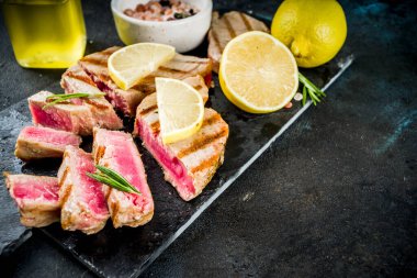 Ton balığı biftek limon ve baharat, koyu mavi beton arka plan kopya alanı üstten görünüm ile ızgara