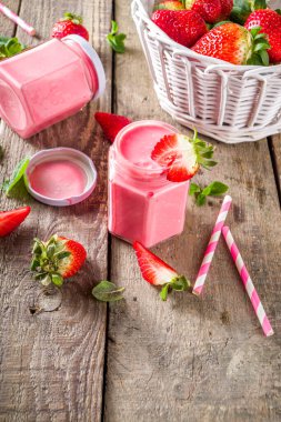 Çilekli milkshake şişede, taze çilek ve nane şekerli güneş ışığı yaz tahtası ve cam arka plan, kopyalama alanı