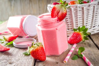 Çilekli milkshake şişede, taze çilek ve nane şekerli güneş ışığı yaz tahtası ve cam arka plan, kopyalama alanı