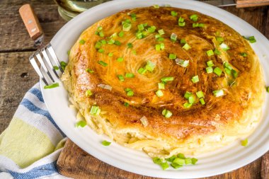 Ev yapımı kahvaltı spagetti omleti, yumurta ve yeşil soğan, ahşap kırsal arka plan. 