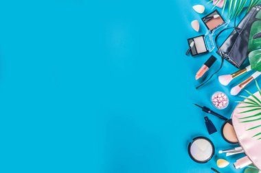 Profesyonel makyaj seti, tropik yaz yaprakları, kadın çantası. Makyaj malzemeleri. Lüks dekoratif kozmetik düz döşeme, üst görünüm, maket. Güzellik blogcusu kavramı. Moda turkuaz arkaplan