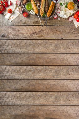 Yaz bbq partisi. Çubukta şiş kebap, kıyma ve tavuk etinden. Lula kebap, geleneksel Kafkas Asya yemeği. Çeşitli soslar, baharatlar ve domateslerle, gri taş arka plan, yukarıdaki boşluğu kopyala