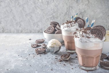 Kahve, sütlü ve kurabiyeli milkshake. Dondurma ve çikolatalı kurabiyeler tatlı latte kokteyli. Kaşık ve vanilyalı dondurmayla birlikte gri beton masada. Boşluğu kopyala