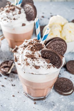 Kahve, sütlü ve kurabiyeli milkshake. Dondurma ve çikolatalı kurabiyeler tatlı latte kokteyli. Kaşık ve vanilyalı dondurmayla birlikte gri beton masada. Boşluğu kopyala