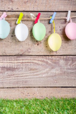 Renkli paskalya yumurtaları yeşil ve ahşap bahçe terasında. Komik bahar dekorasyonu. Mutlu Paskalya tebrik kartı geçmişi. 