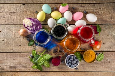 Easter organic and zero waste concept. Easter eggs painted with natural egg dye, fruits and vegetables. Wooden background 