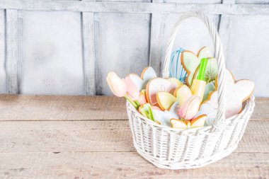 Pastel renkli Paskalya kurabiyeleriyle mutlu paskalya arkaplanları - tavşanlar, yumurtalar, çiçekler, kelebekler, ahşap kırsal arka plan, düz afiş alanı