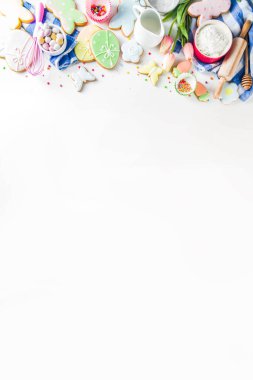 Geleneksel Paskalya tavşanı ve yumurta kurabiyeleri, şeker parçacıkları, malzemeler, çatal bıçaklarla Paskalya pişirme geçmişi var. Beyaz tablo arkaplan kopyalama alanı düzeni