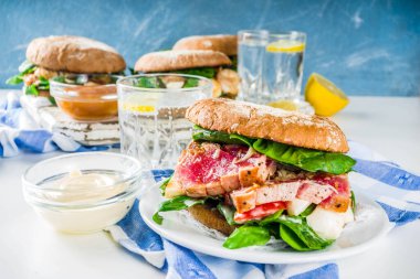 Çeşitli deniz ürünleri ve balık burger çeşitleri. Izgara karides, somon, ton balığı, levrek, taze otlar, mozzarella peyniri ve bebek ıspanağı ile ev yapımı sağlıklı burger.. 