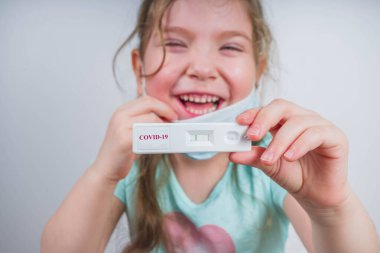 Dünya çapında koronavirüs salgını konsepti. Salgın COVID 19, 2019-NCoV. Elinde Sars-Cov-2 virüsü için negatif test şeridi olan kız çocuğu. Coronavirus iyileştirme kavramından sonra