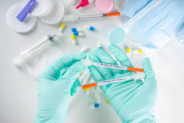 Worldwide coronavirus epidemic concept. Pandemic COVID-19, 2019-nCoV. Testing of coronavirus vaccine. Syringe with covid-19 vaccine, against the background of drugs, pills and medical supplies