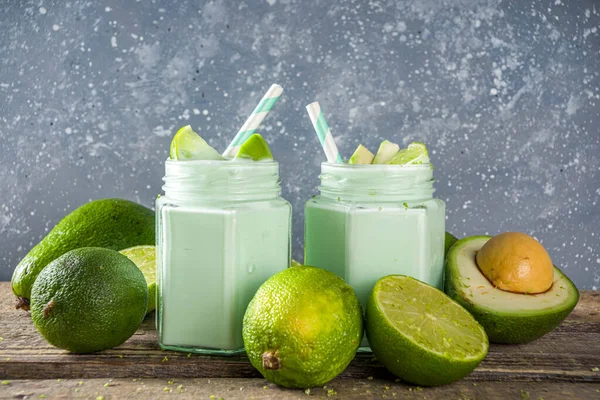 Avocado Milk Shake or Smoothie, Yogurt with Avocado and Lime Juice, with Fresh Avocados and limes on wooden background copy space