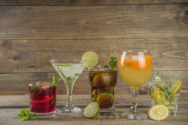 Yaz içecekleri, kokteyller ve kokteyller. Aperol spritz, Cube libre Gimlet martini, mojito, sangria. Ahşap arka planda çeşitli soğuk yaz barları ve parti içecekleri fotokopi alanı