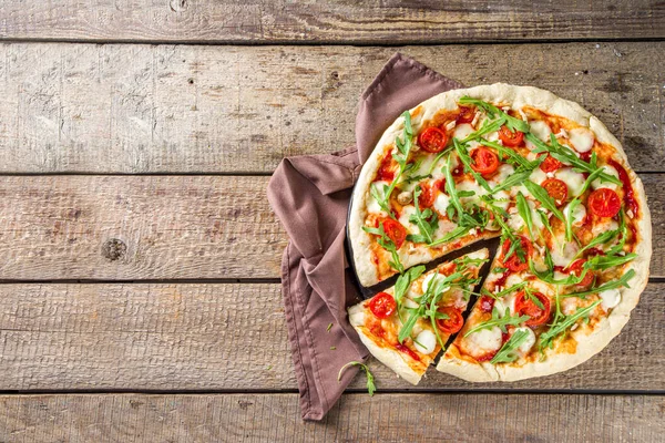 Flatbread homemade vegan pizza. Italian classic pizza with tomato cherry, mozzarella cheese and fresh arugula, copy space