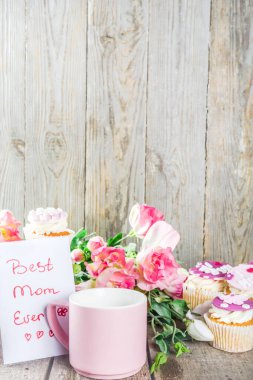 Anneler Günün kutlu olsun. Anneler günü tatlı kekleri, hediye kutuları, kahve fincanı, çiçekler. Ahşap arkaplan kopyalama alanı