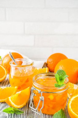 Taze dilimlenmiş Portakallar ve nane yaprakları, Beyaz ahşap arka plan kopya alanı ile ev yapımı turuncu reçel
