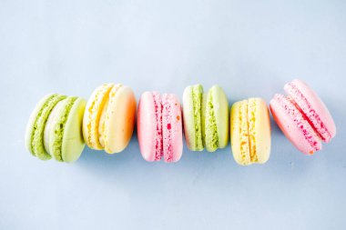 Klasik renkli macarons. Altı pembe, sarı ve yeşil macaron çerezleri üstten görünüm kopya alanı