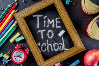 Siyah kara tahta arka planda okul eğitim malzemeleri. Okul konseptine geri dönelim. Üst görünüm düz metin için kopya alanı ile yatıyordu