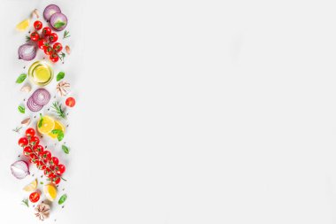Baharatlar, sebzeler ve otlarla yemek pişirmek taze fesleğen, biberiye, domates, sarımsak, soğan, beyaz mutfak masasında limon. Üst görünüm kopyalama alanı. Yemek pişirmek için sağlıklı malzemeler
